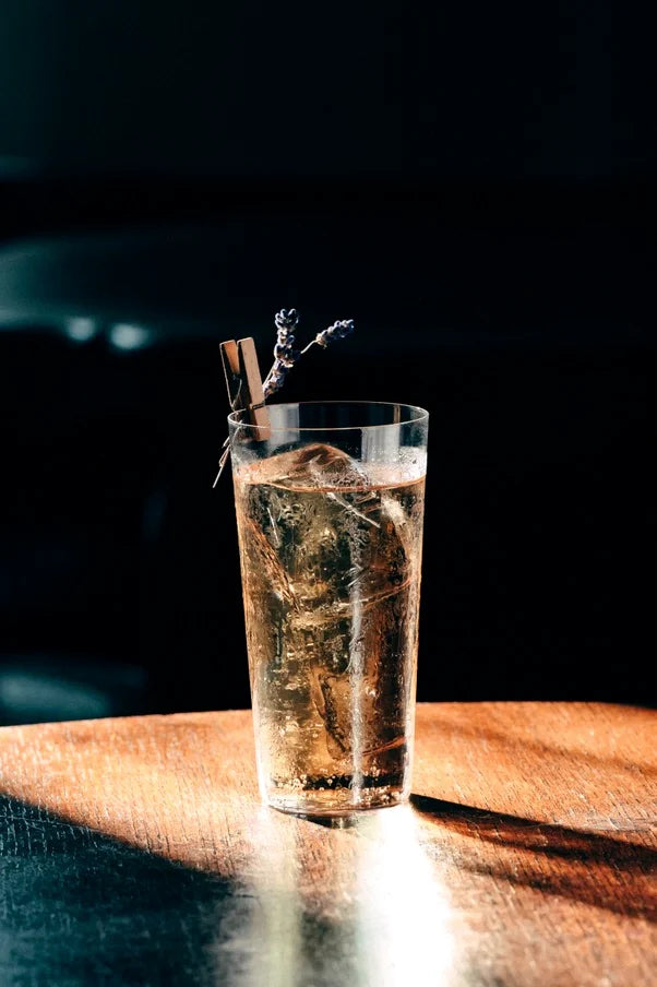 Coctel alto con lavanda sobre barra de madera