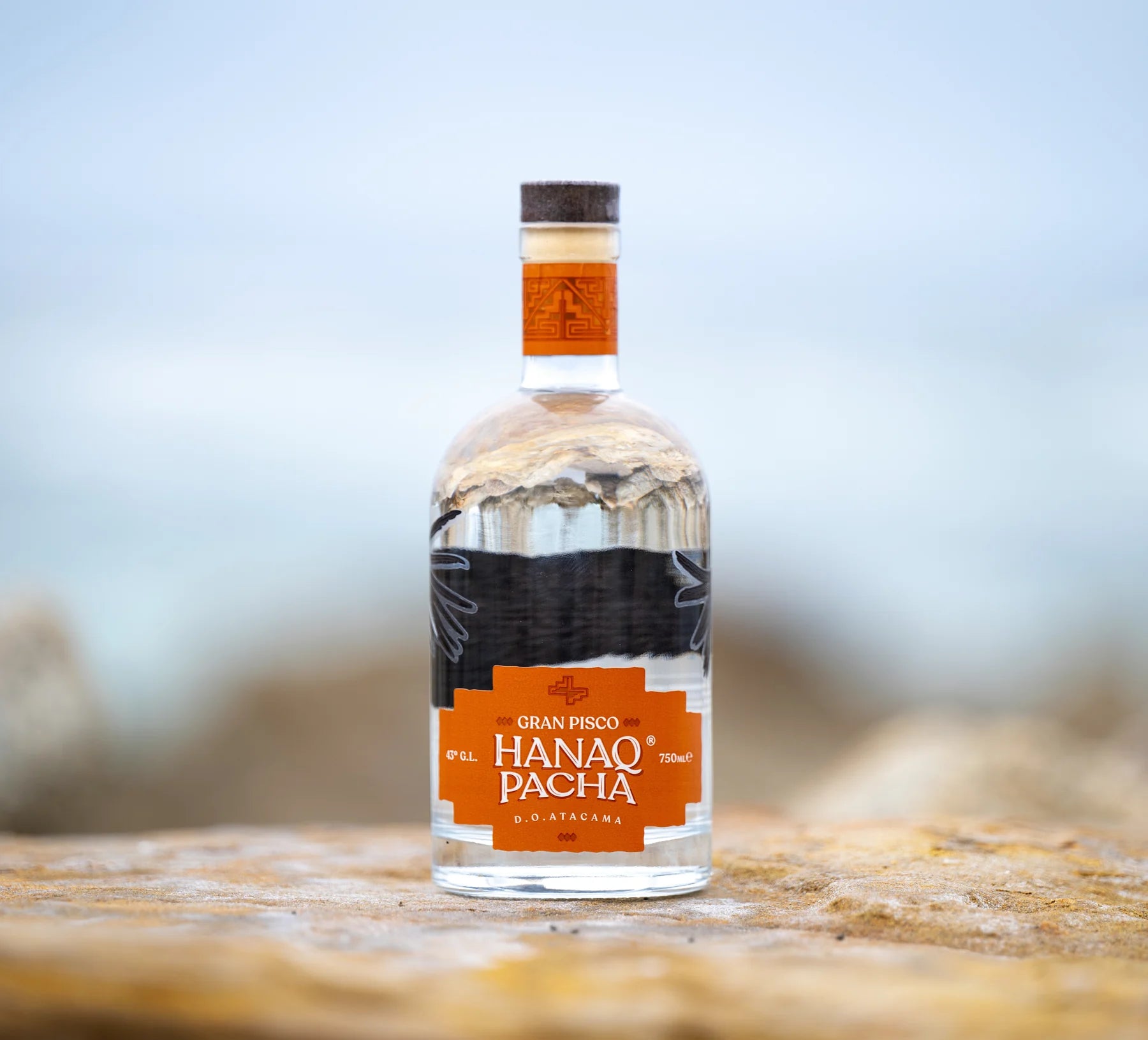 Botella Hanaq Pacha fotografiada en paisaje costero de Pan de Azucar